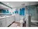 Bright bathroom with a white vanity, framed mirrors, and a glass shower enclosure at 14723 Seminole Trl, Seminole, FL 33776