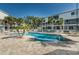 Inviting community pool with palm trees and a brick patio, surrounded by well-maintained landscaping and lounge chairs at 14723 Seminole Trl, Seminole, FL 33776