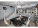 The dining room boasts a black marble table and statement chandelier, steps leading up to the second floor at 14723 Seminole Trl, Seminole, FL 33776