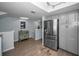 Bright kitchen area with stainless steel fridge and adjacent entryway with staircase at 14723 Seminole Trl, Seminole, FL 33776