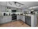 Updated kitchen features modern gray cabinetry, granite countertops, stainless steel appliances, and wood floors at 14723 Seminole Trl, Seminole, FL 33776