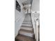 Stylish staircase with white railings, wooden steps, and artwork displayed on the wall at 14723 Seminole Trl, Seminole, FL 33776