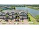 Aerial view of townhomes featuring brick driveways with a scenic lake and fountain at 18860 Beautyberry Ct, Lutz, FL 33558