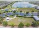 Aerial view of the common area with playground, parking lot, and green space with trees at 18860 Beautyberry Ct, Lutz, FL 33558
