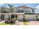 Beautiful townhome exterior with a two-car garage, lush landscaping, and a well-maintained brick driveway at 18860 Beautyberry Ct, Lutz, FL 33558