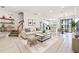 Bright living room with white floors, modern furnishings, and an open floor plan leading into the kitchen at 18860 Beautyberry Ct, Lutz, FL 33558