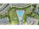 Aerial view of the pool with lounge seating, a pool house and meticulously manicured landscaping throughout the community at 18860 Beautyberry Ct, Lutz, FL 33558