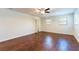 A spacious bedroom with dark wood floors, a ceiling fan, and a double window at 18914 5Th St, Lutz, FL 33548