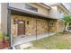 Inviting covered front porch with stone accents, decorative sconces, and a solid wood entry door at 18914 5Th St, Lutz, FL 33548