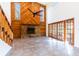 Open floor plan featuring a stone fireplace, soaring wood paneling, access to private patio, and a staircase at 18914 5Th St, Lutz, FL 33548