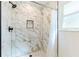 A beautifully tiled walk-in shower with a modern shower head and storage niche at 18914 5Th St, Lutz, FL 33548
