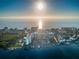Sunrise aerial view of condo building, marina, pool, tennis court, and beachside community on the Gulf at 19111 Vista Bay Dr # 304, Indian Shores, FL 33785
