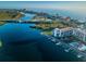 Beautiful aerial view of waterfront condos, a bridge, a marina, and a swimming pool in a coastal setting at 19111 Vista Bay Dr # 304, Indian Shores, FL 33785