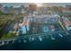 Aerial view showcases waterfront condo, tennis courts, boat docks, parking and pool in a sunny coastal setting at 19111 Vista Bay Dr # 304, Indian Shores, FL 33785