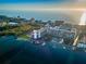 Coastal aerial of condo building with tennis court, boat docks, and pool on the beach and Gulf coast at 19111 Vista Bay Dr # 304, Indian Shores, FL 33785