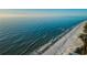 Gorgeous aerial shot of sandy beach meeting the turquoise ocean on a sunny day, inviting relaxation and coastal charm at 19111 Vista Bay Dr # 304, Indian Shores, FL 33785