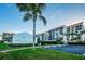 Exterior view of condo featuring private balconies, lush landscaping, and convenient parking with palm tree accents at 19111 Vista Bay Dr # 304, Indian Shores, FL 33785