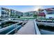Exterior view of the condominium, grassy common area, and a waterfront dock at 19111 Vista Bay Dr # 304, Indian Shores, FL 33785