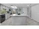Spacious kitchen with gray cabinets, white countertops, tile backsplash, stainless appliances and a kitchen island at 19111 Vista Bay Dr # 304, Indian Shores, FL 33785