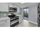 Well-equipped kitchen features stainless steel appliances, stylish backsplash, and convenient access to a balcony at 19111 Vista Bay Dr # 304, Indian Shores, FL 33785