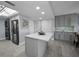 Kitchen with gray cabinets, an island, stainless steel appliances and gray tile flooring. Includes stacked washer/dryer at 19111 Vista Bay Dr # 304, Indian Shores, FL 33785