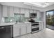 Updated kitchen with gray cabinets, stainless steel appliances, white quartz countertops and access to the balcony at 19111 Vista Bay Dr # 304, Indian Shores, FL 33785