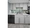 Modern kitchen with sleek gray cabinets, stainless steel appliances, and stylish backsplash at 19111 Vista Bay Dr # 304, Indian Shores, FL 33785