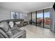Relaxing living room featuring a comfortable leather sofa, modern artwork, and sliding glass doors to the balcony at 19111 Vista Bay Dr # 304, Indian Shores, FL 33785