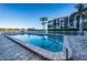 Community swimming pool next to a condominium building with lush greenery and manicured landscaping at 19111 Vista Bay Dr # 304, Indian Shores, FL 33785