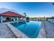 Sparkling community swimming pool with a red tile roofed cabana and ample lounge seating for residents at 19111 Vista Bay Dr # 304, Indian Shores, FL 33785