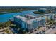 Exterior of condo with parking lot and lush tropical landscaping, with marina and water views at 19531 Gulf Blvd # 205, Indian Shores, FL 33785
