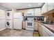 Cozy kitchen features a stacked washer/dryer, white appliances, and plenty of cabinet space at 19531 Gulf Blvd # 205, Indian Shores, FL 33785