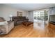 Cozy living room with sliding doors to the balcony, wood floors, comfortable seating, and natural lighting at 19531 Gulf Blvd # 205, Indian Shores, FL 33785