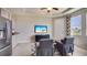 Comfortable living room area featuring tile floors, a TV, gray chairs, and stainless-steel refrigerator at 19695 Gladeview Way, Land O Lakes, FL 34638