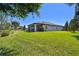 Expansive backyard with lush lawn and screened-in patio overlooking picturesque landscaping and serene water feature at 21627 Pearl Crescent Ct, Land O Lakes, FL 34637
