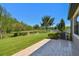 Enjoy the serene backyard featuring lush green lawn, pond view, and a paved patio, perfect for outdoor relaxation at 21627 Pearl Crescent Ct, Land O Lakes, FL 34637