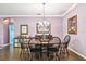 Formal dining room featuring a wooden table with black chairs, stylish decor, and tile flooring at 21627 Pearl Crescent Ct, Land O Lakes, FL 34637