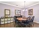 Elegant dining room with a wooden table and black chairs, decorative artwork, and wood-look tile flooring at 21627 Pearl Crescent Ct, Land O Lakes, FL 34637