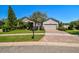 Charming home with a brick paver driveway, manicured lawn, and mature landscaping at 21627 Pearl Crescent Ct, Land O Lakes, FL 34637