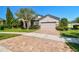 Inviting home featuring a brick paver driveway, well-maintained landscaping, and a manicured lawn at 21627 Pearl Crescent Ct, Land O Lakes, FL 34637