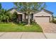 Charming home with well-manicured lawn, mature landscaping, and a brick paver driveway at 21627 Pearl Crescent Ct, Land O Lakes, FL 34637