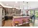 Modern kitchen featuring dark wood cabinets, stainless steel appliances, granite countertops, and a center island with seating at 21627 Pearl Crescent Ct, Land O Lakes, FL 34637