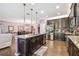 Open concept kitchen with a large island, stainless steel appliances, dark wood cabinetry, and tile flooring at 21627 Pearl Crescent Ct, Land O Lakes, FL 34637