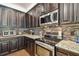 This kitchen features dark cabinets, stainless appliances, and tiled backsplash at 21627 Pearl Crescent Ct, Land O Lakes, FL 34637