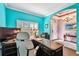 Bright office with blue walls, shutters on windows and an arched entryway to the front foyer at 21627 Pearl Crescent Ct, Land O Lakes, FL 34637