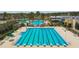Large community swimming pool with lap lanes, beach entry, and splash park in a tropical setting at 21627 Pearl Crescent Ct, Land O Lakes, FL 34637