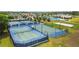 Aerial view of tennis and basketball courts surrounded by mature trees and green grass at 21627 Pearl Crescent Ct, Land O Lakes, FL 34637