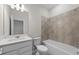 Bathroom showcasing tiled shower-tub, bright vanity with modern fixture, and contemporary tile floors at 2731 Winding Creek Trl, North Port, FL 34289