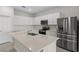 Modern kitchen features white cabinets, stainless steel appliances, and a center island with stone countertops at 2731 Winding Creek Trl, North Port, FL 34289