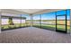 A screened lanai features beautiful brick pavers and an expansive view of the community pond at 2731 Winding Creek Trl, North Port, FL 34289